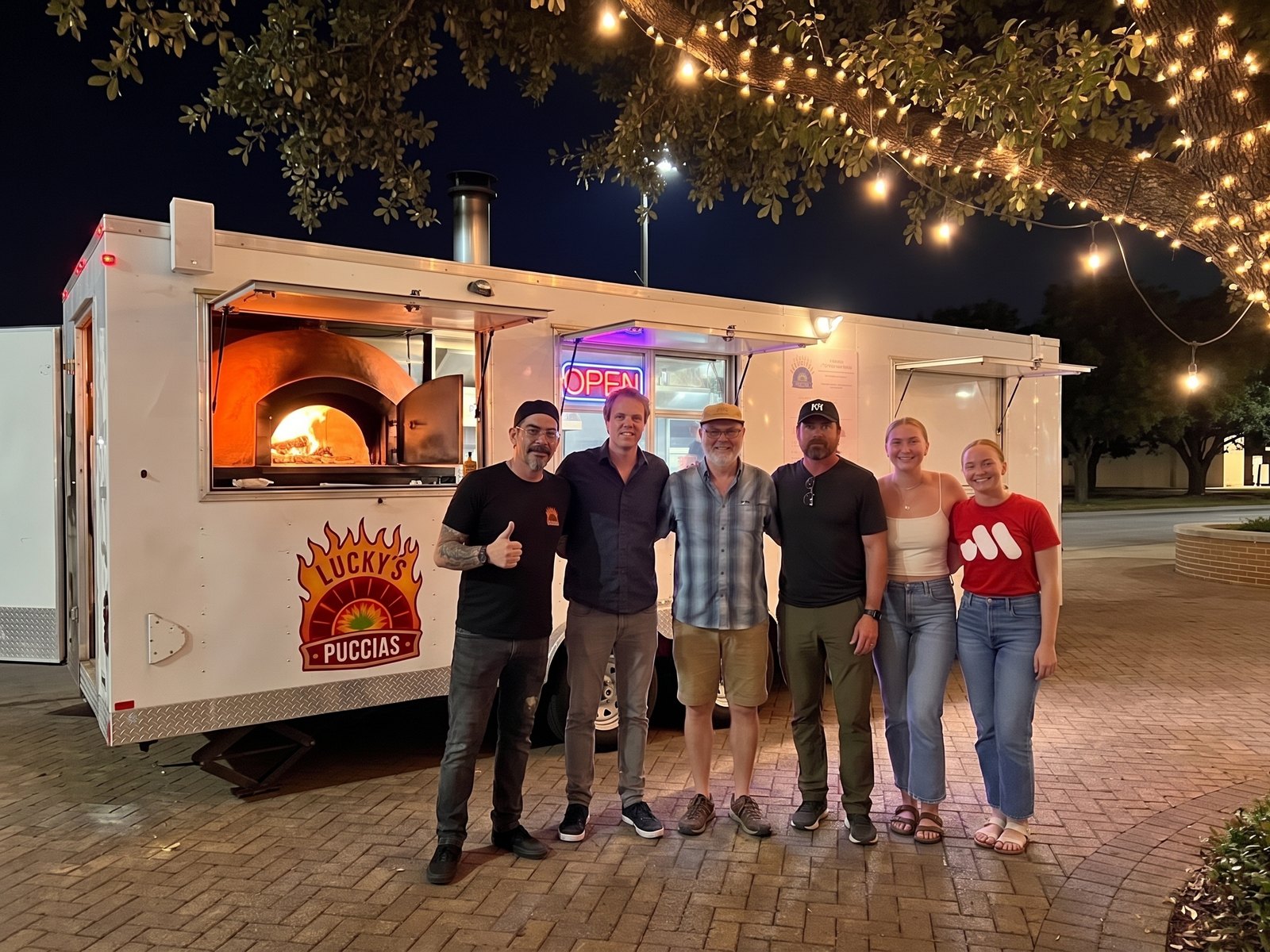 Lucky and superfans in front of the trailer at night